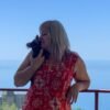 Selena holding Choco chocolate long coat Chihuahua puppy during sea adventure