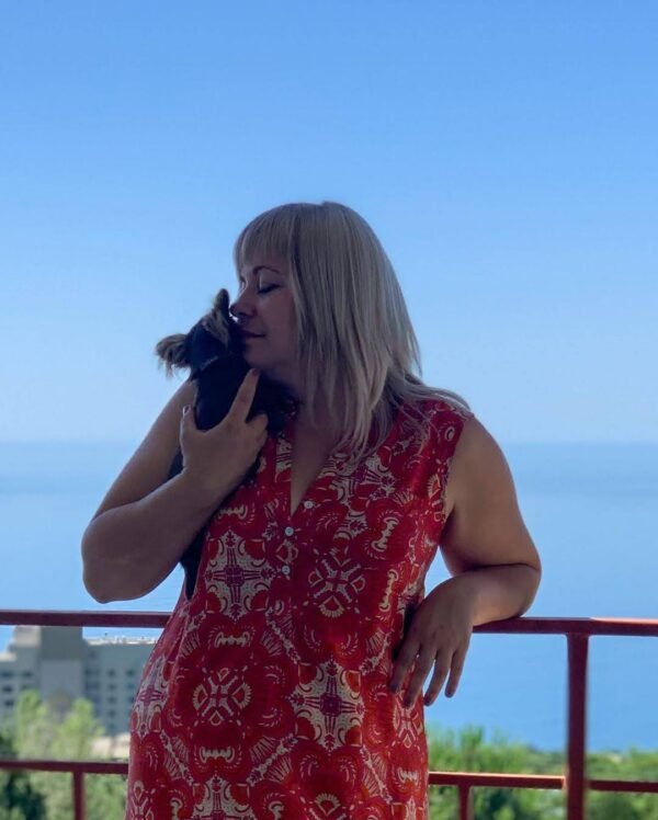 Selena holding Choco chocolate long coat Chihuahua puppy during sea adventure