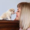Breeder kissing Luna Teacup Long Hair Chihuahua puppy's face